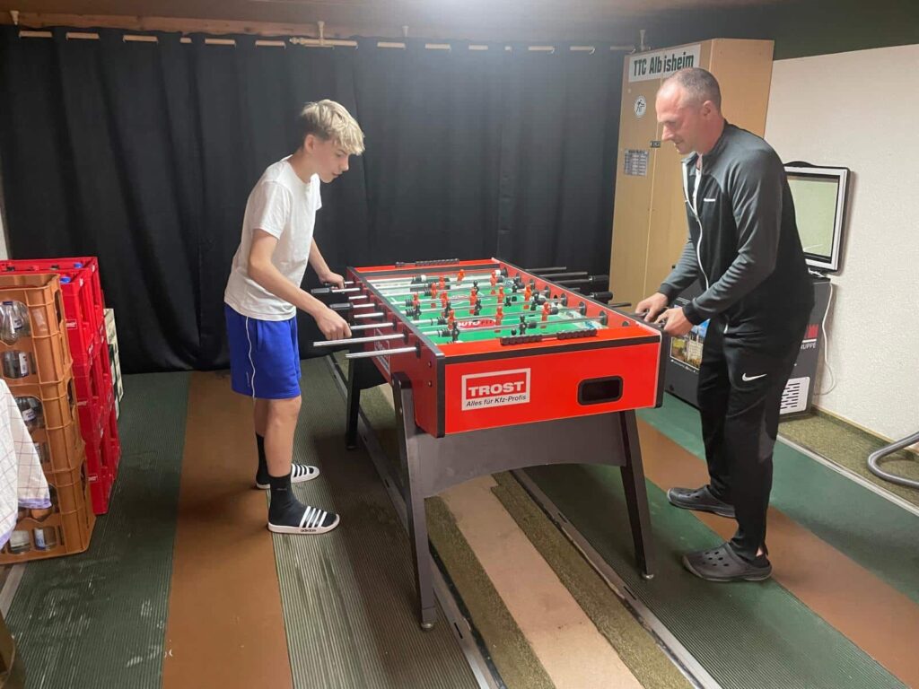 a man and boy playing foosball