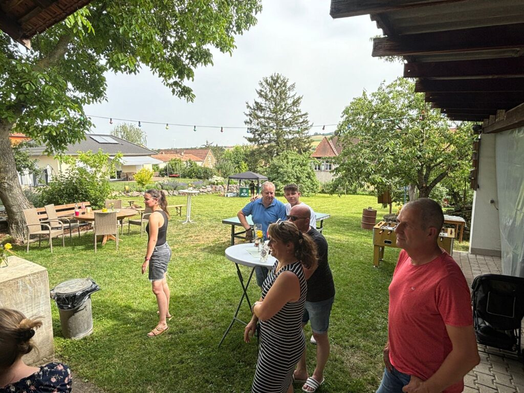a group of people standing around a table outside