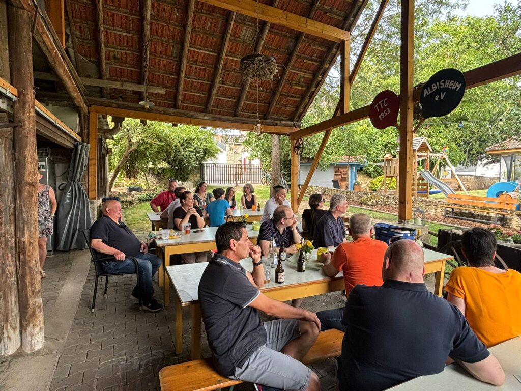 a group of people sitting around tables outside