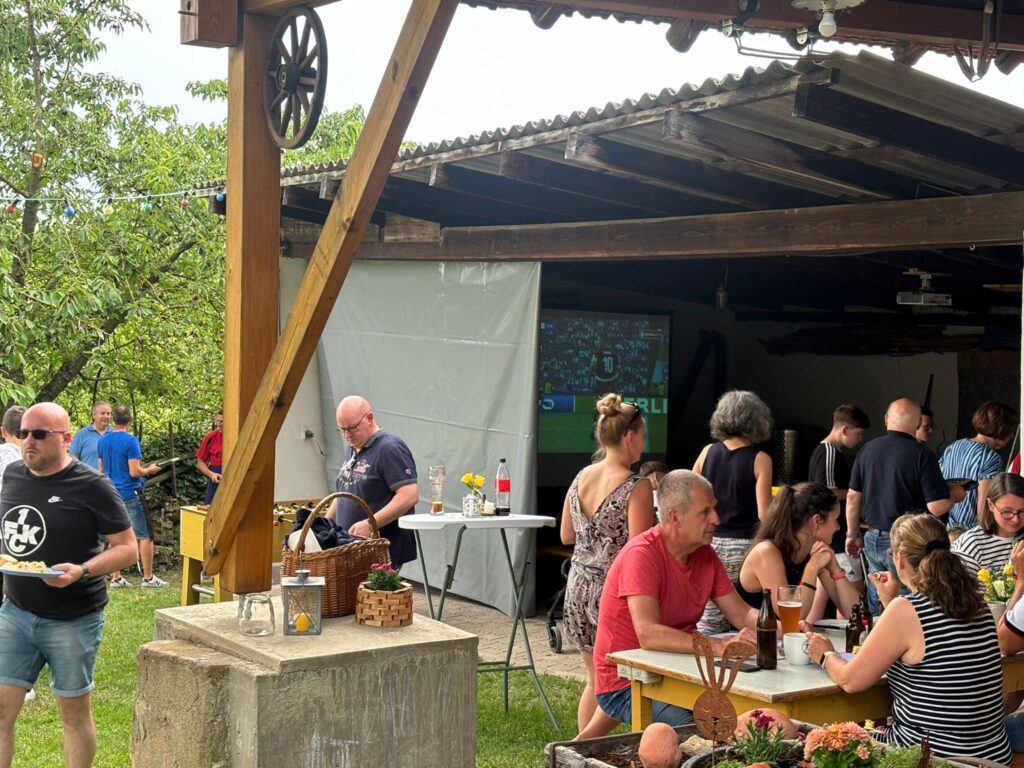 a group of people sitting at tables outside