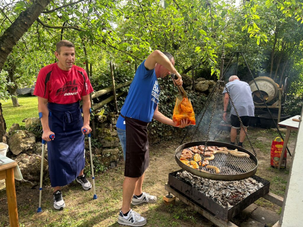 a group of men cooking food on a grill