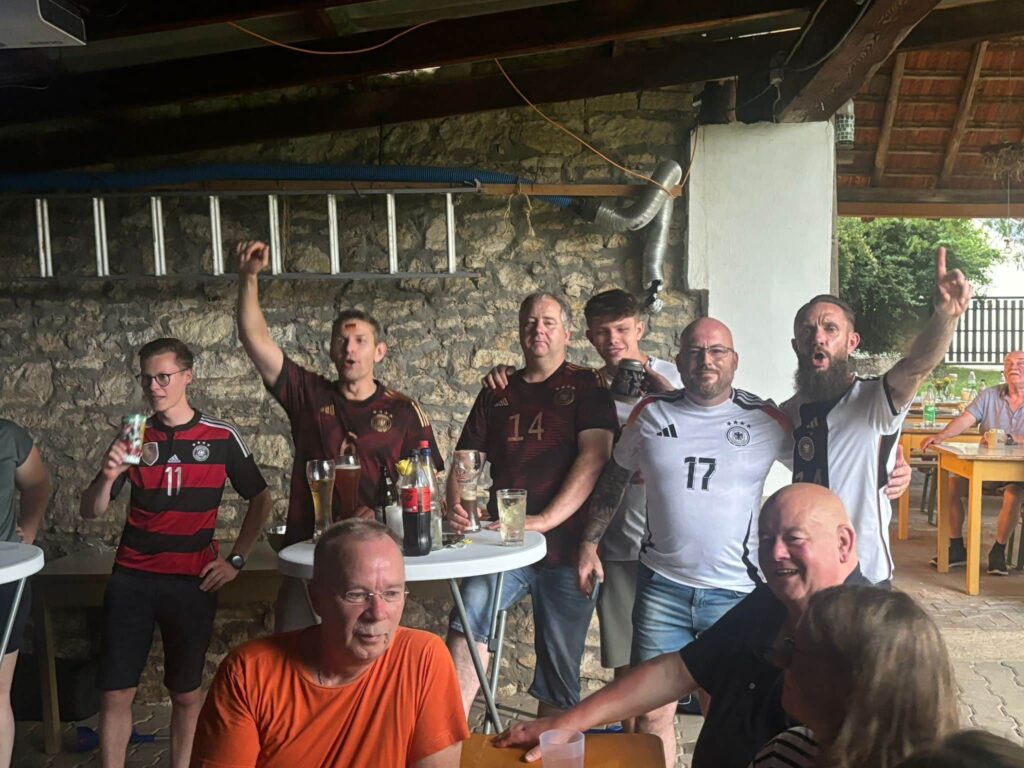 a group of men standing around a table with drinks