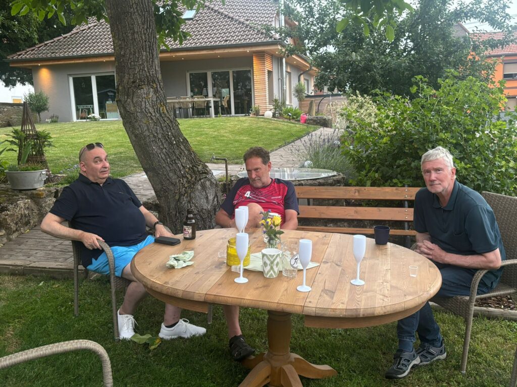 a group of men sitting at a table outside