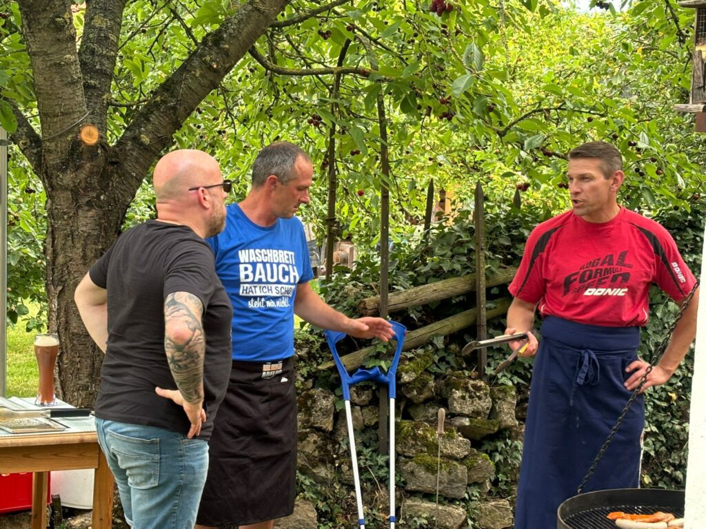a group of men standing around a grill