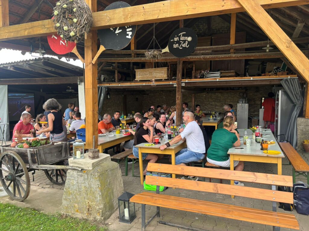 a group of people sitting at tables outside
