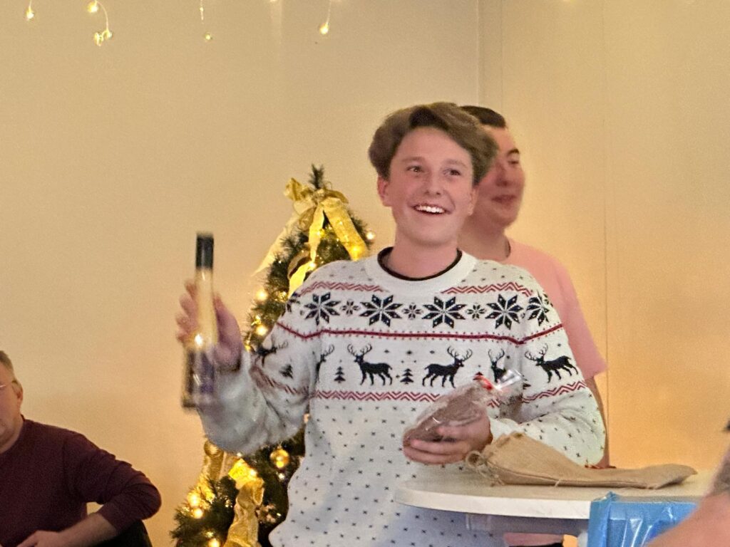 a boy holding a bottle of wine