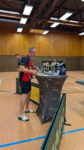 a man standing at a podium with trophies on it