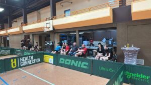 a group of people sitting in chairs in a gym