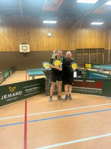 two men holding paddles in a gym